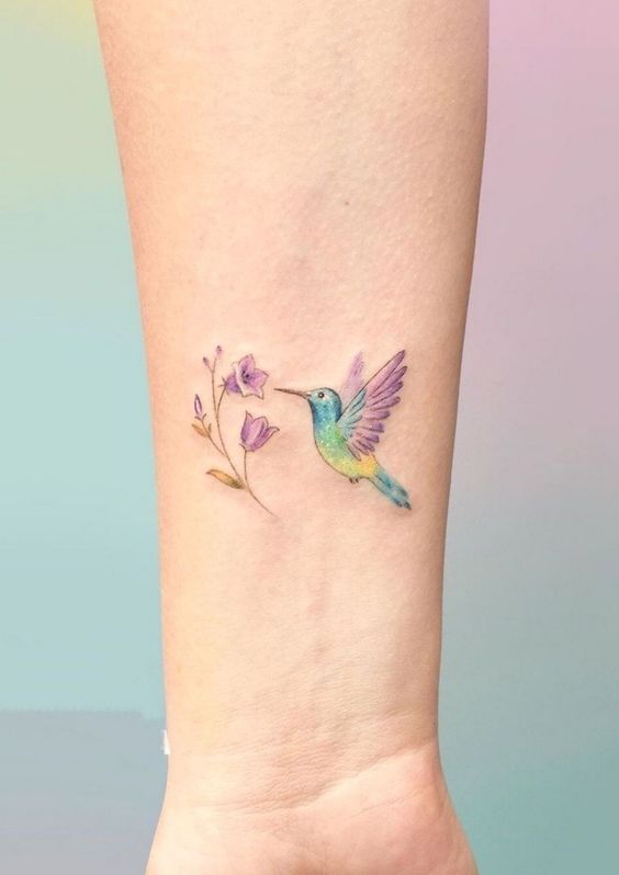 Small hummingbird and flower tattoo on the forearm for women