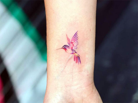 Colored hummingbird tattoo on the wrist for women