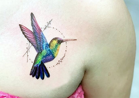 Colored hummingbird tattoo on the collarbone for women