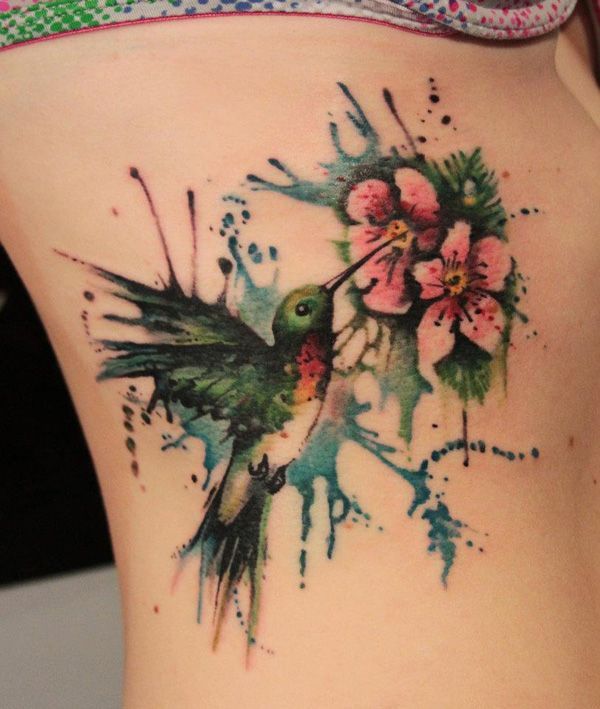 Colored hummingbird and flower tattoo on the side for women