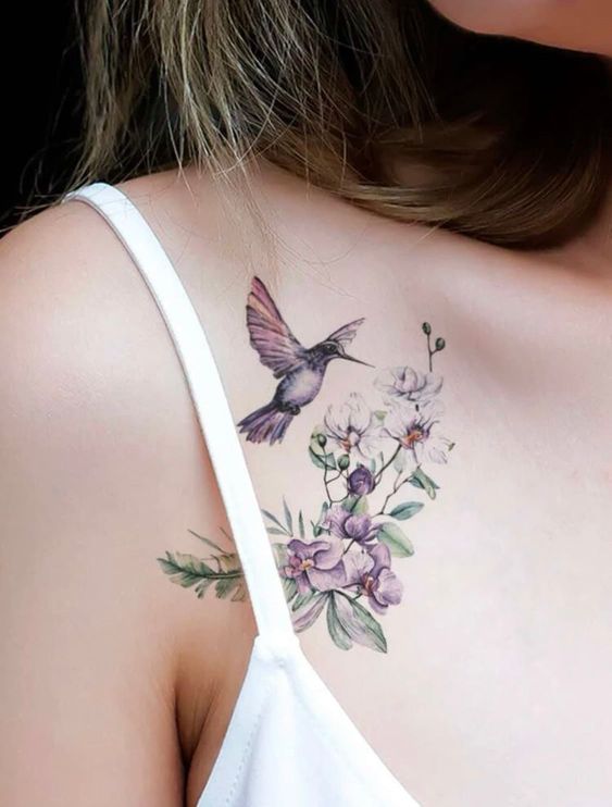 Colored hummingbird and flower tattoo on the collarbone for women