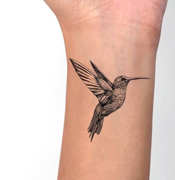 Large hummingbird tattoo on the forearm for women