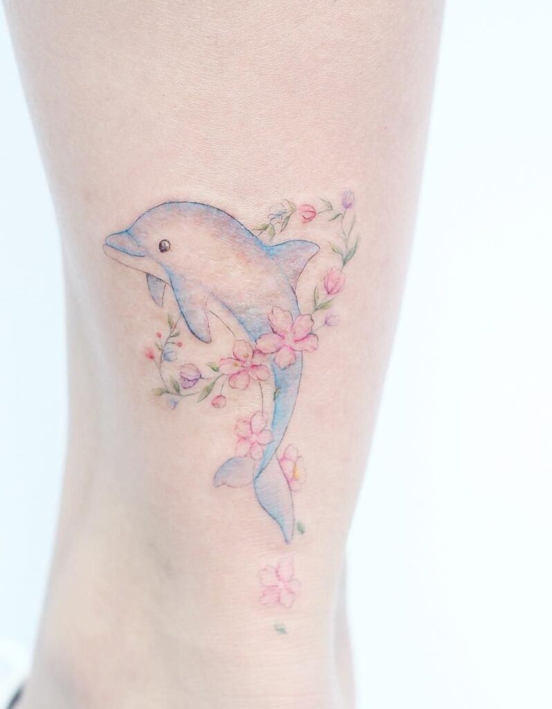 Colorful dolphin tattoo on the leg for women