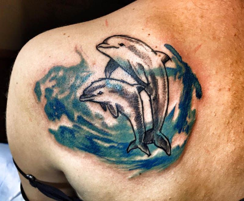 Large dolphin tattoo on the shoulder blade for men