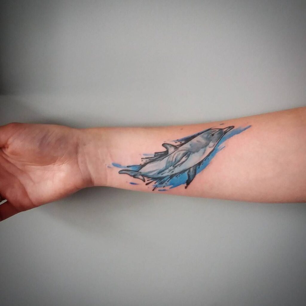 Colorful dolphin tattoo on the forearm for women