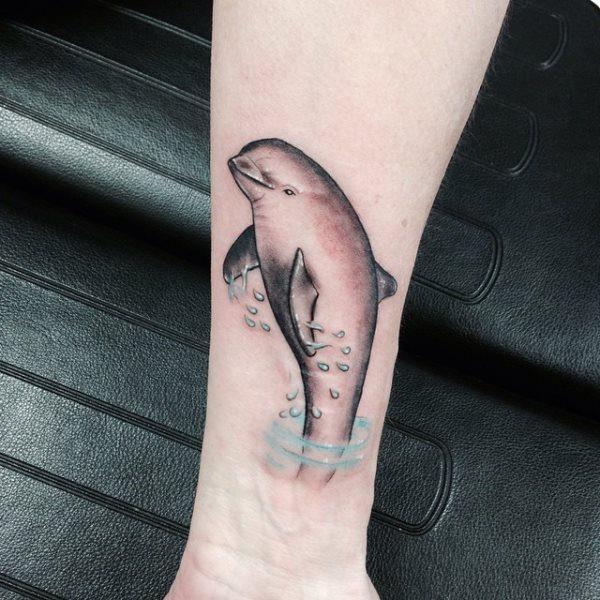 Tattoo of a dolphin on the forearm for women