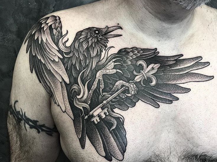 Large tattoo of a raven with a key on the chest for men