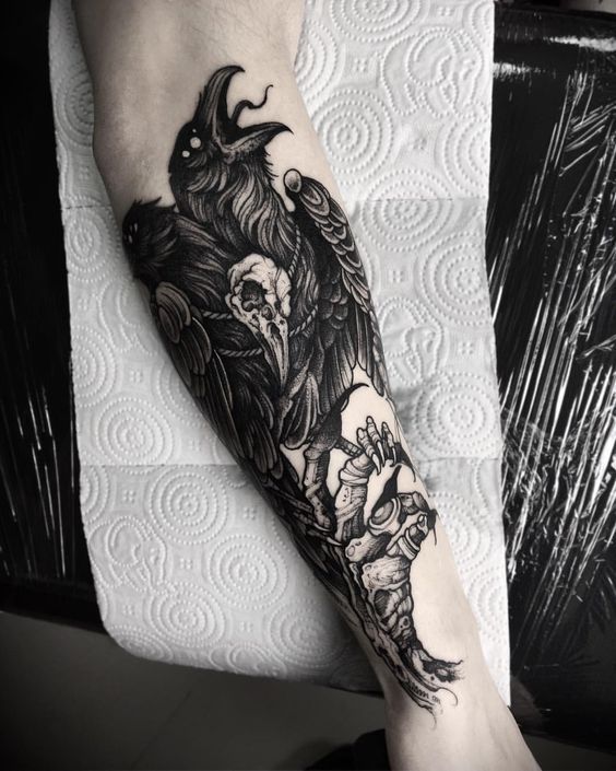 Large tattoo of a raven on the forearm for men