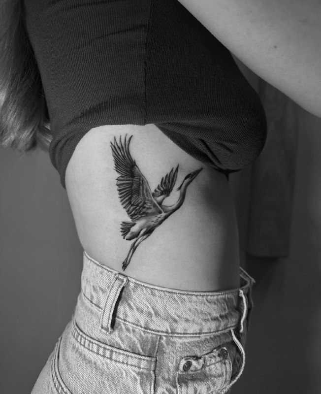 Crane tattoo on the side for women