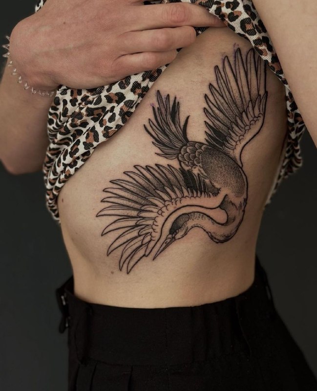 Large crane tattoo on the side for women