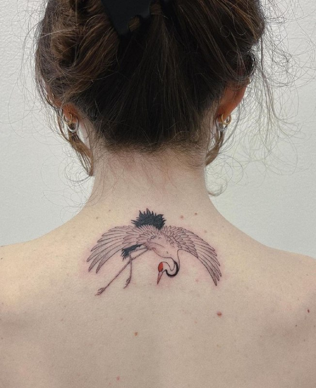 Crane tattoo on the back for women