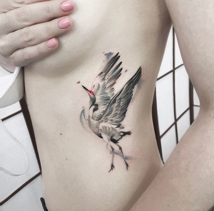 Crane tattoo on the side for women