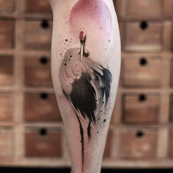 Color tattoo of a crane on a calf for men