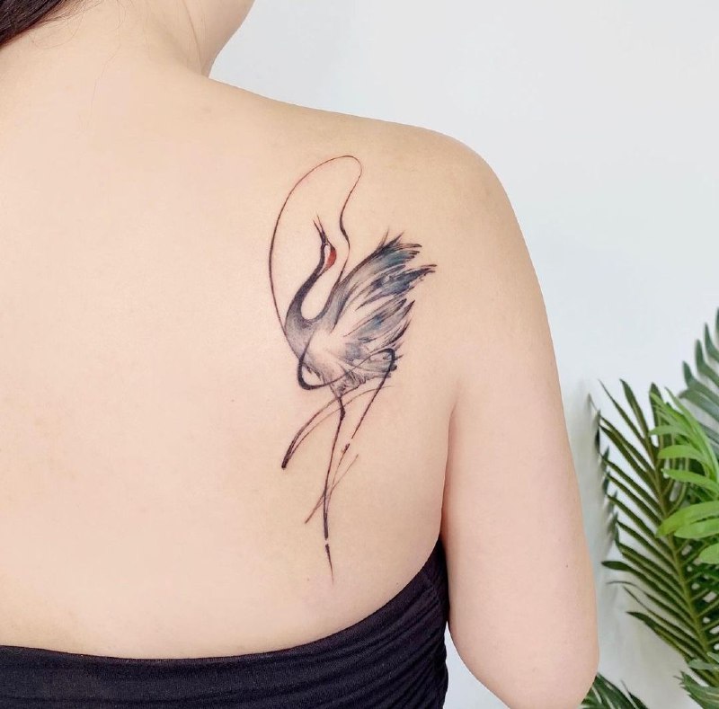 Colorful crane tattoo on the shoulder blade for women