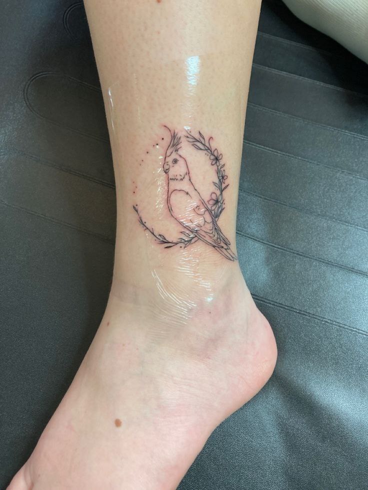 Parrot tattoo on the shin for women