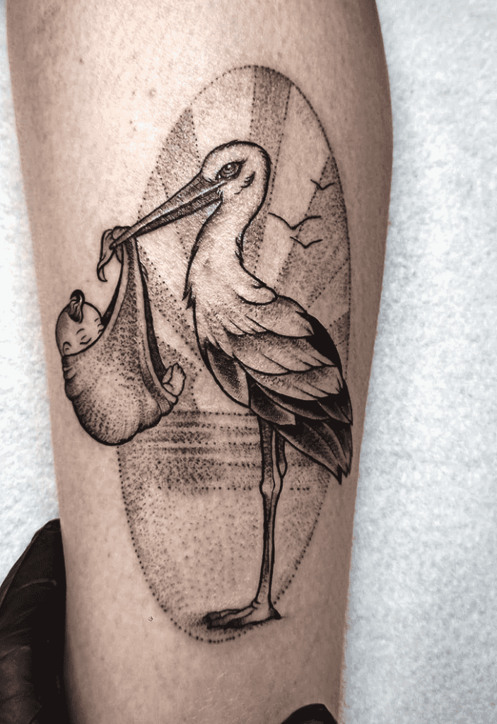 Tattoo of a stork with a baby on her shin for women