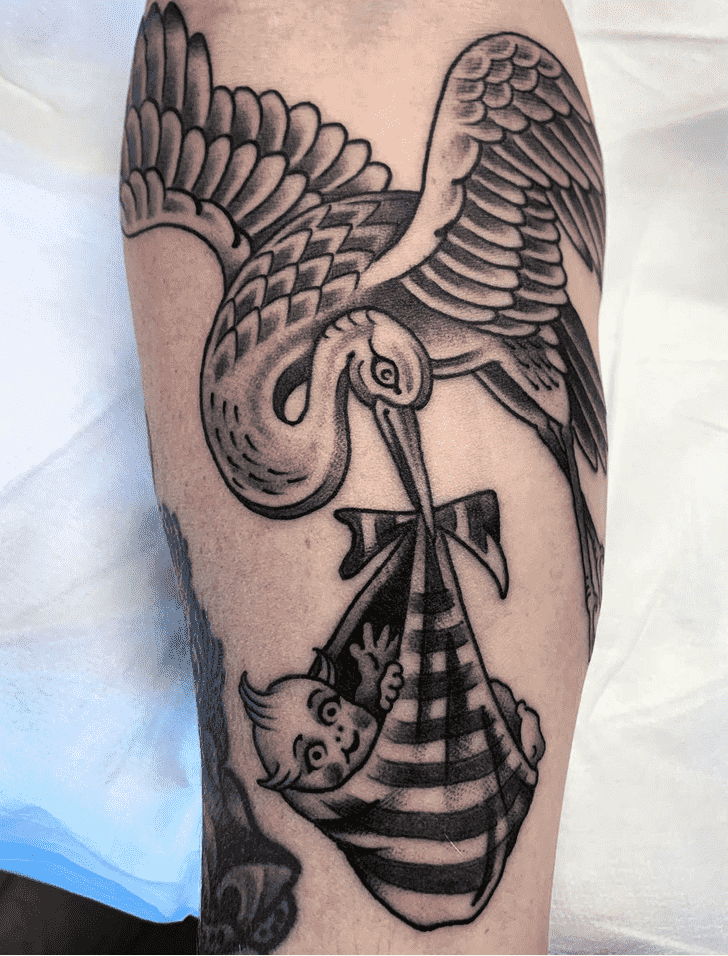 Tattoo of a stork with a baby on the forearm for women