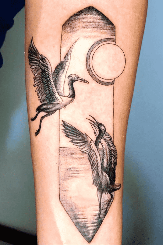 Tattoo of two storks on the forearm for men