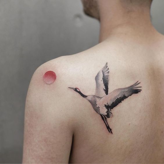 Colored stork tattoo on the shoulder blade for men