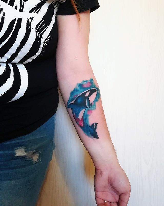 Colored orca tattoo on the forearm for women