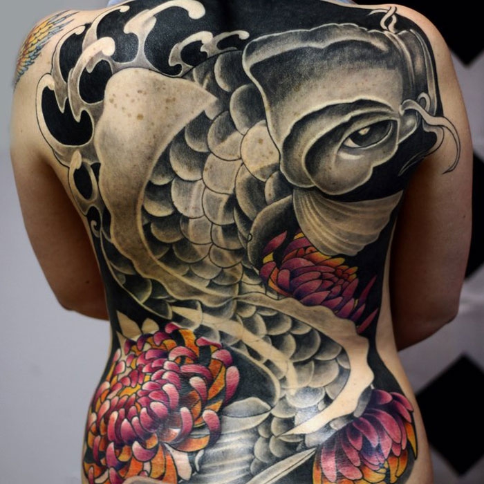 Color carp tattoo on the back for women