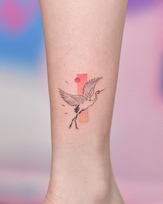 Colorful crane tattoo on the shin for women