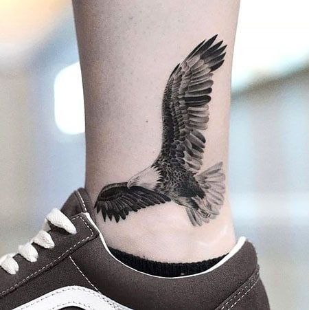 Large tattoo of an eagle on the ankle for men