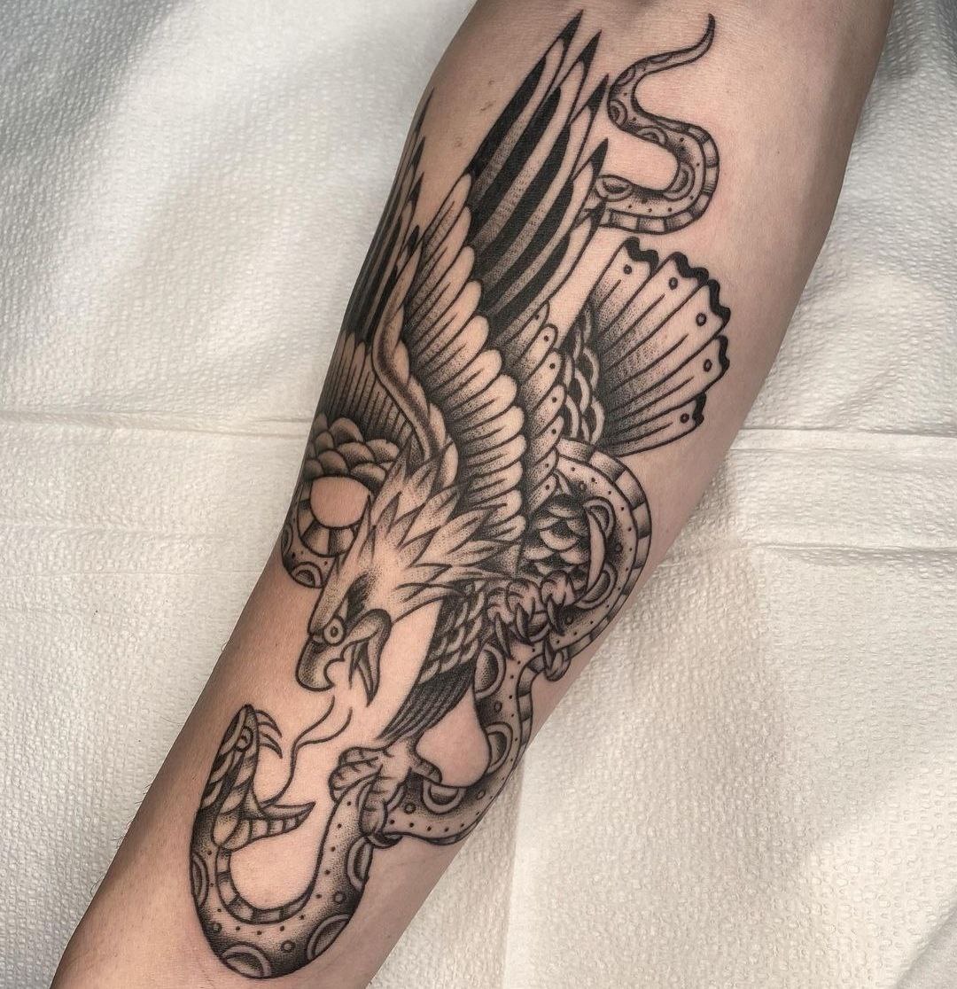 Tattoo of an eagle with a snake on the forearm for men