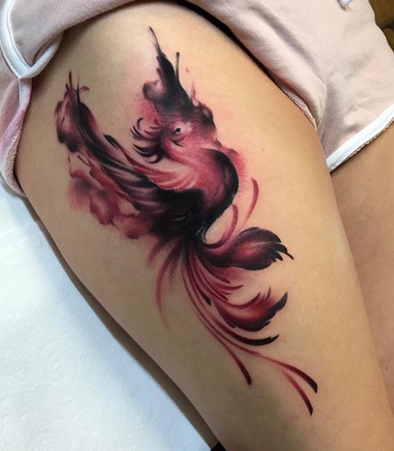 Colorful firebird tattoo on the thigh for women