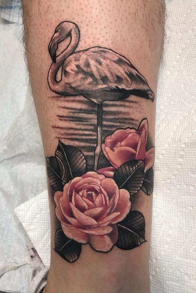 Large flamingo tattoo with a rose on his shin for men