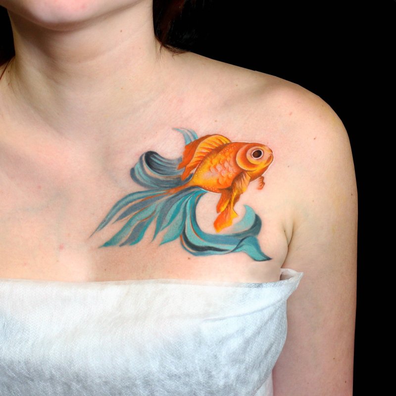 Colored goldfish tattoo on the collarbone for women