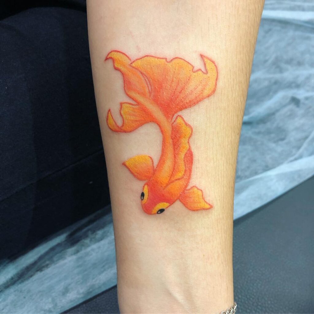 Colored goldfish tattoo on forearm for women