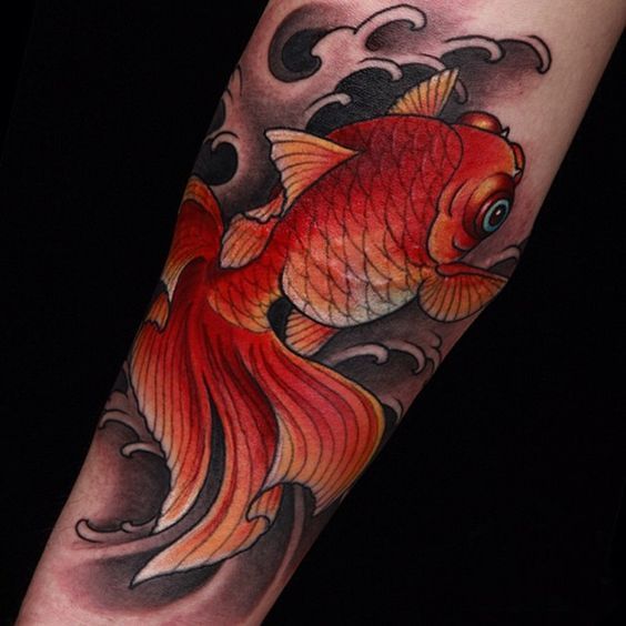 Colored goldfish tattoo on forearm for women