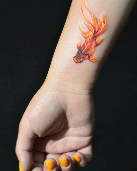 Colored goldfish tattoo on the forearm for women