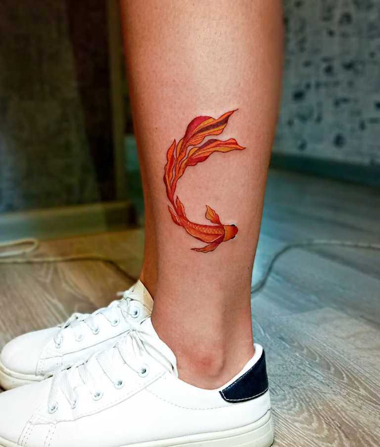 Colored goldfish tattoo on the shin for women