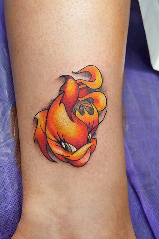 Colored goldfish tattoo on the shin for women