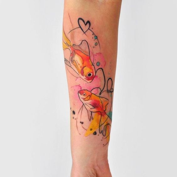 Colorful tattoo of two goldfish on the forearm for women