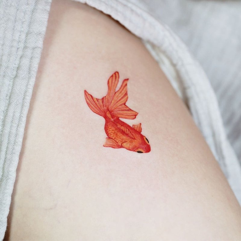 Colorful goldfish tattoo on the thigh for women