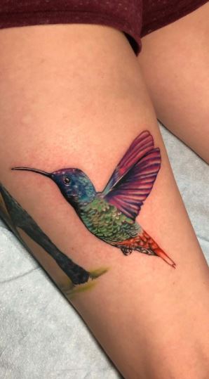 Colored hummingbird tattoo on thigh for women