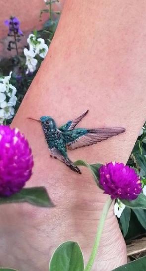 Small hummingbird tattoo on the shin for women