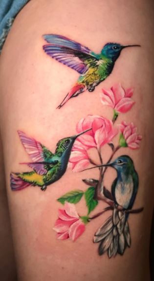 Color tattoo of three hummingbirds with flowers on the thigh for women