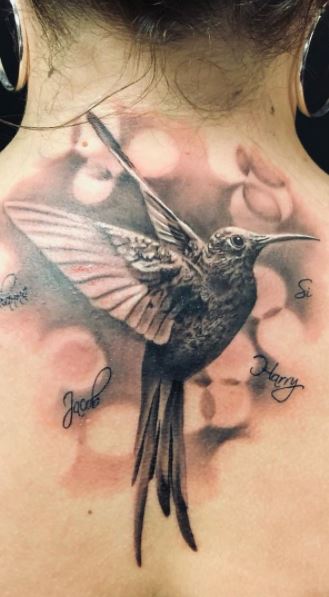 Colored hummingbird tattoo on the back for women