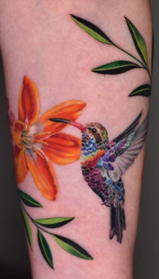 Large hummingbird tattoo with lily on leg for women