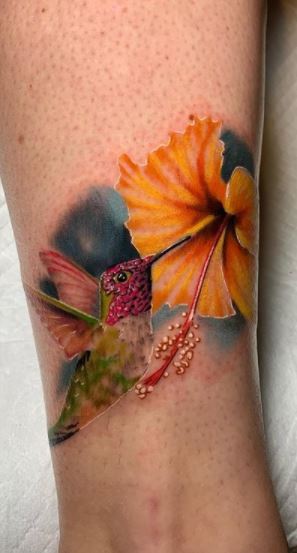 Large hummingbird tattoo on lower leg for women