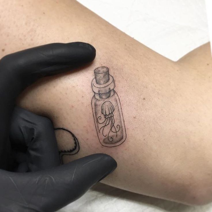 Jellyfish tattoo in a flask on the shoulder for men