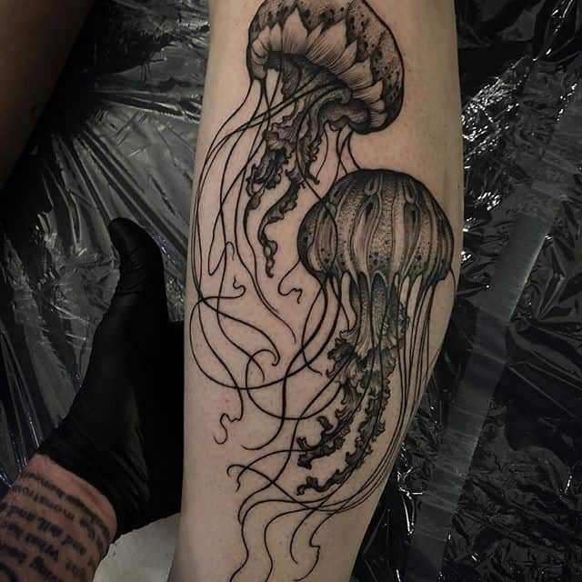 Large tattoo of two jellyfish on the shin for men