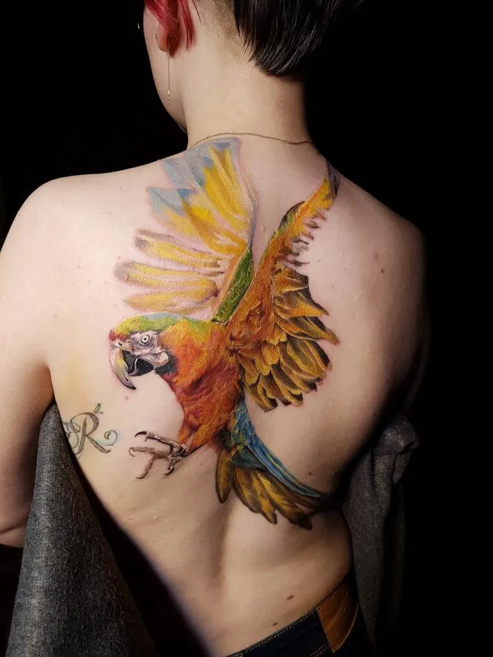 Large parrot tattoo on the back for women