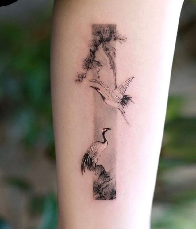 Tattoo of two storks on the arm for women