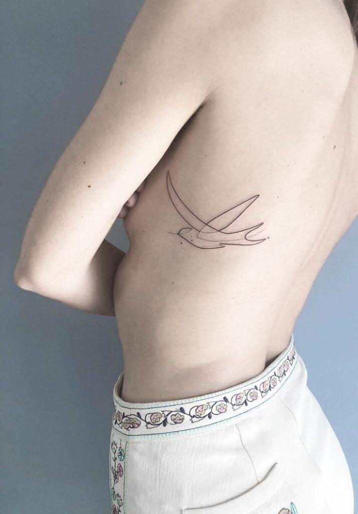 Swallow tattoo on the side for women