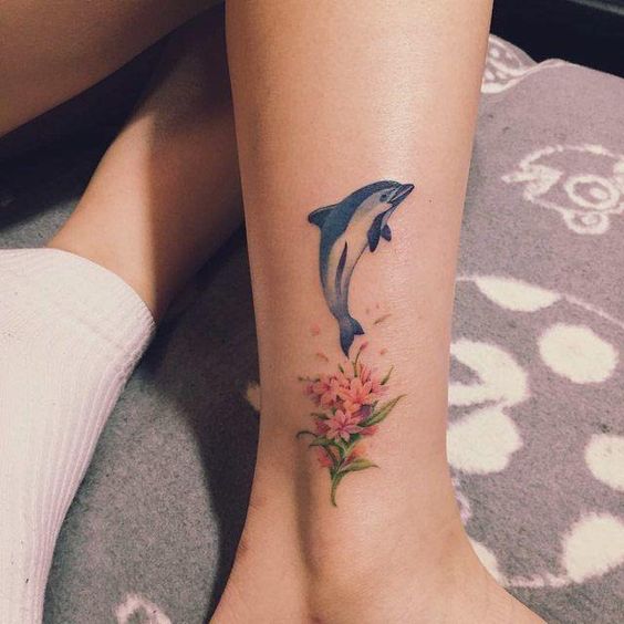 Colorful dolphin tattoo on the shin for women